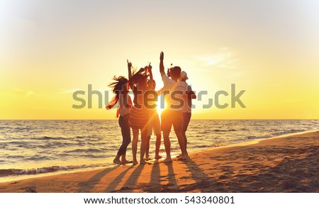 group of happy young people dancing at the beach on beautiful summer sunset Royalty-Free Stock Photo #543340801
