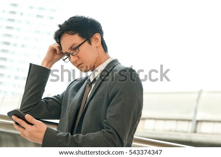 Businessman serious Disappointed after checking news from smart phone, copy space on Right side.