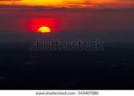 Sunset in clouds over red sunset sky background