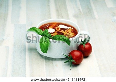Tomato, red pepper soup, sauce with olive oil, rosemary and smoked paprika on a wooden background. 