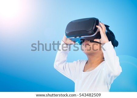 Asian Chinese little girl experiencing virtual reality eyeglassses in isolated background.