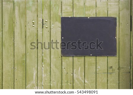 empty information sign on green wooden background, selective focus