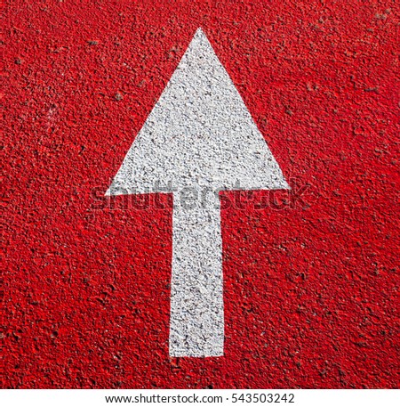 White arrow on the red painted asphalt surface. 