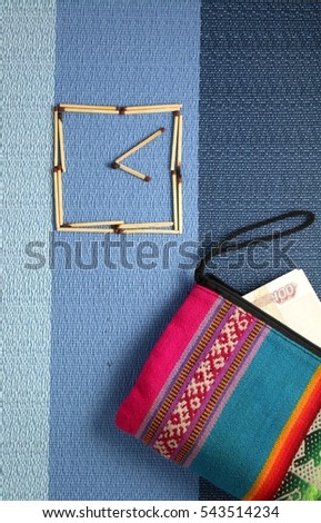 clock and a multicolored retro vintage purse with money