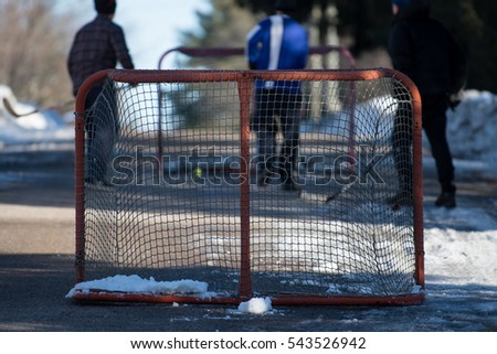 Hockey players playing street hockey in winter