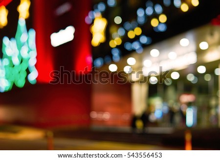 Blurred elements of Christmas decorations in the form of stars on the building of a large shopping mall. Bokeh basic background for design