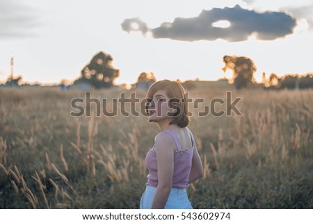 Silhouette of a young woman relaxing on a beautiful sunset. Woman enjoying nature sunset.