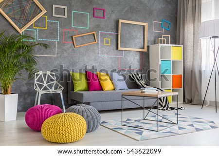 Spacious modern lounge with grey sofa and colorful pillows and poufs Royalty-Free Stock Photo #543622099