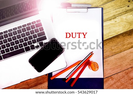 DUTY word, text at notepad in wooden table background , retro concepts in wooden with notebook and smartphone