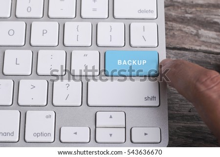 Close up of finger on keyboard button with BACKUP word