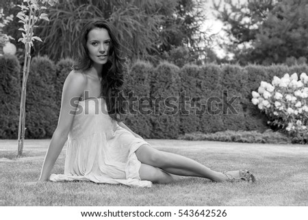 Full length of attractive young woman in sundress relaxing at park