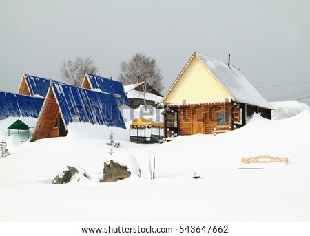 Wooden small houses for rest at coast of the frozen lake 
