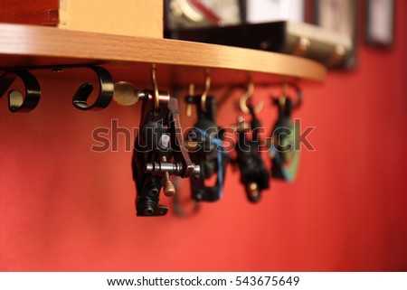Parts of tattoo machine hanging on wooden shelf, close up view