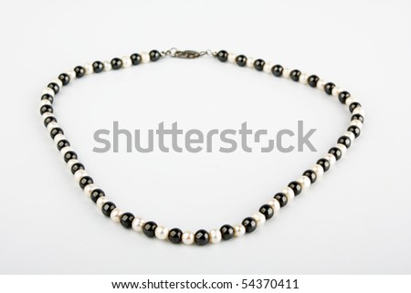 White pearls and black stone beads on a thread
