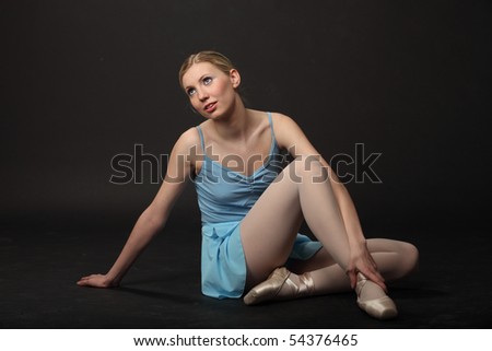 Beautiful young blond ballerina sit