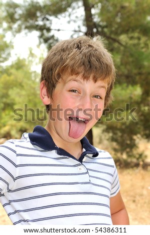 A boy in a forest glade make faces photographer