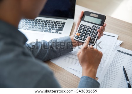 Unrecognizable businessman using calculator Royalty-Free Stock Photo #543881659