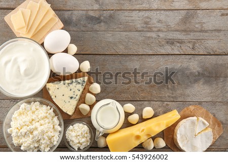 Different types of dairy products on wooden background Royalty-Free Stock Photo #543926002