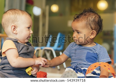 Babys playing together in the kindergarten. Royalty-Free Stock Photo #543939718