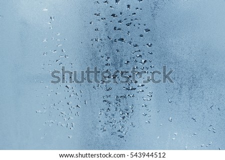 Condensation on the windows a strong, high humidity in the room, large water droplets flow down the window, cold tone