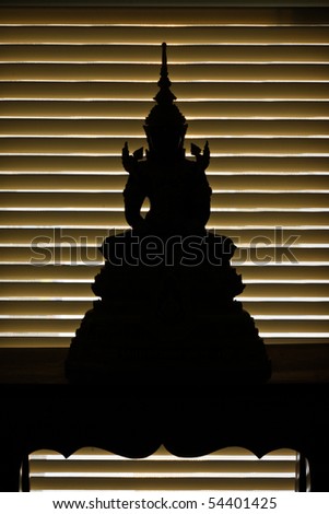 Silhouette of buddha at stand in the front of window light