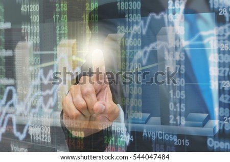 Businessman pointing the trading graph of stock market on the virtual screen on photo blurred of cityscape building background, Business stock market and trading concept