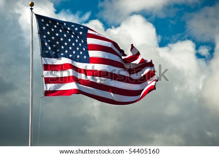 American flag against a cloudy sky on a windy day