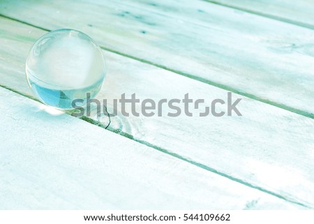 Abstract picture of glass ball on wooden floor, pastel color idea of fortune the best future for background, greeting cards, happiness festival, New years wishes, Valentine day