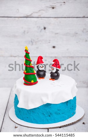 Bright fresh homemade cake with penguins and a christmas tree to new year party