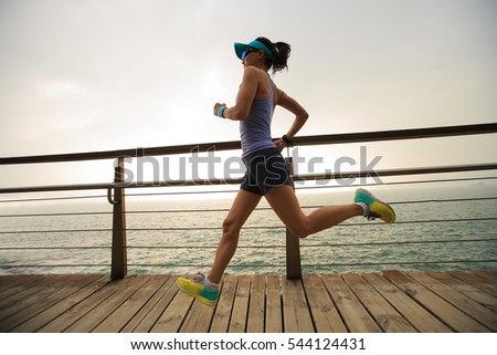 young fitness sports woman  trail runner running on seaside