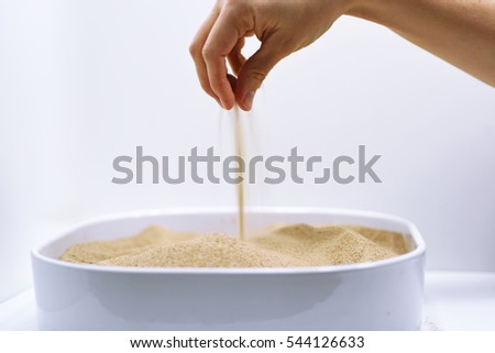 Woman hand with falling sand Royalty-Free Stock Photo #544126633