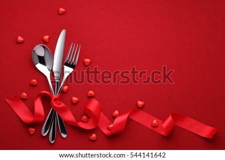 Fork knife spoon with ribbon on red Royalty-Free Stock Photo #544141642