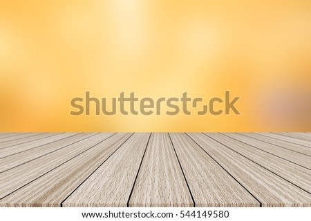 abstract blurry luxury gold yellow color background with wood floorboard perspective for promote and advertise product on display