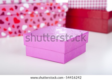 Pink gift box for birthday or valentines gift.  Shallow depth of field with gift boxes in background.