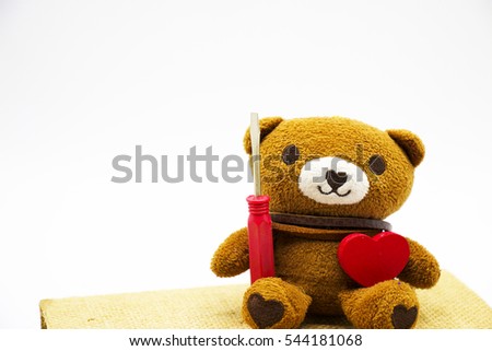 Bear with tools to fix the broken hearts is sitting on love diary on white background.