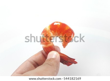 Hand holding cooked tiger prawn dipped with sauce isolated on white background