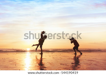 photographer working with couple on the beach, professional wedding photography