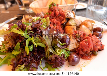 Baked swordfish fillets served with tomato salsa, olives and iceberg salad in the restaurant of Birgu (Vittoriosa), Malta