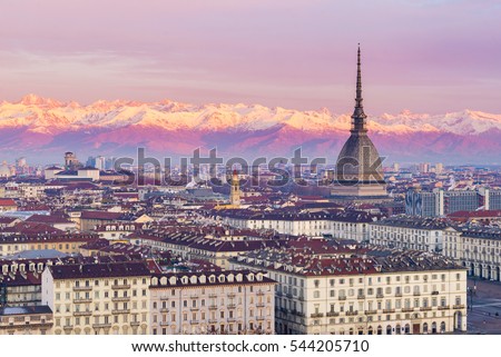 Italia: Torino skyline (Turin, Italy), cityscape at sunrise with details of the Mole Antonelliana towering over the city. Scenic colorful light on the snowcapped Alps in the background. Royalty-Free Stock Photo #544205710