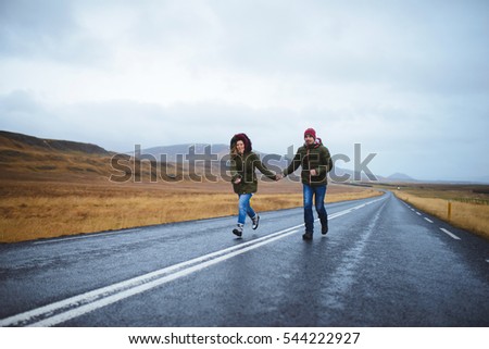 couple running along road in iceland