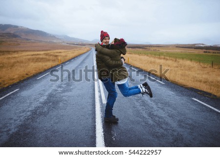 man holding beloved in arms and spinning