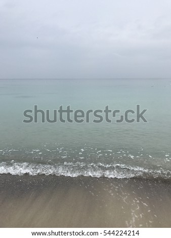 Beautiful seascape with clouds, clear beach without people. grey sky. Background of real heavy clouds
