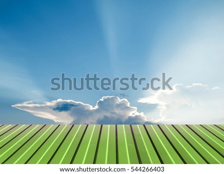 Green flooring against the sky with clouds