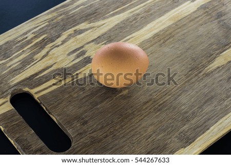 Single raw egg on chopping board. Close up.