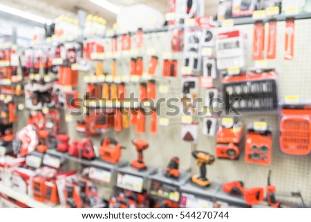 Blurred variety of power tools at tools department in local store Humble, Texas, US. Row of cordless drills, driver, jigsaw, circular saw kit and drill bits. Depicting carpentry and construction tools Royalty-Free Stock Photo #544270744