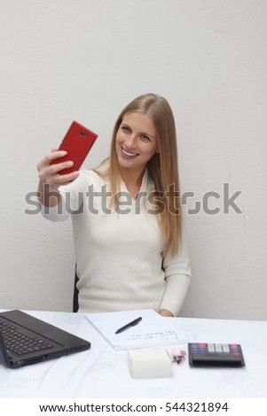 young businesswoman making selfie at her workplace