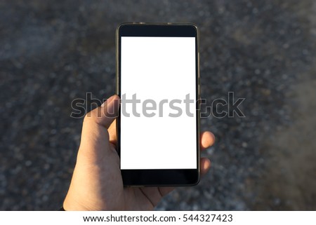 hand holding mobile phone on blur background with white screen