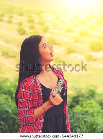 Pretty woman take a photo with classic camera,Hipster girl take photos in nature ,landscape,macro picture .She is traveler happiness and smile