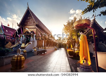 Buddha statue in yellow robe in Wat Rong Khun The Phra Sing in Chiang Rai, Thailand Royalty-Free Stock Photo #544383994
