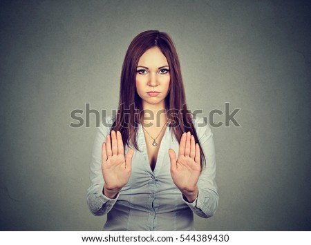 Angry annoyed displeased young woman raising hands up to say no, stop isolated on gray background. Negative human emotion facial expression sign symbol. Negation, discrimination, violence concept. Royalty-Free Stock Photo #544389430